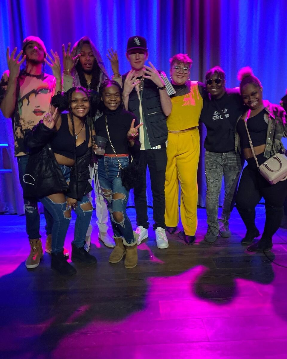 A group of community members standing together on a colorful event stage