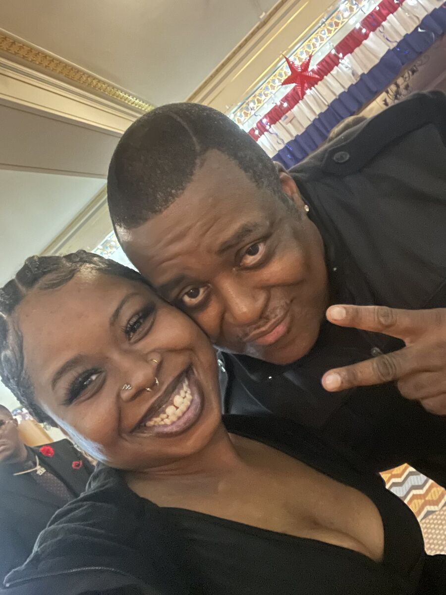 Kay Kay taking a joyful photo with a young community member